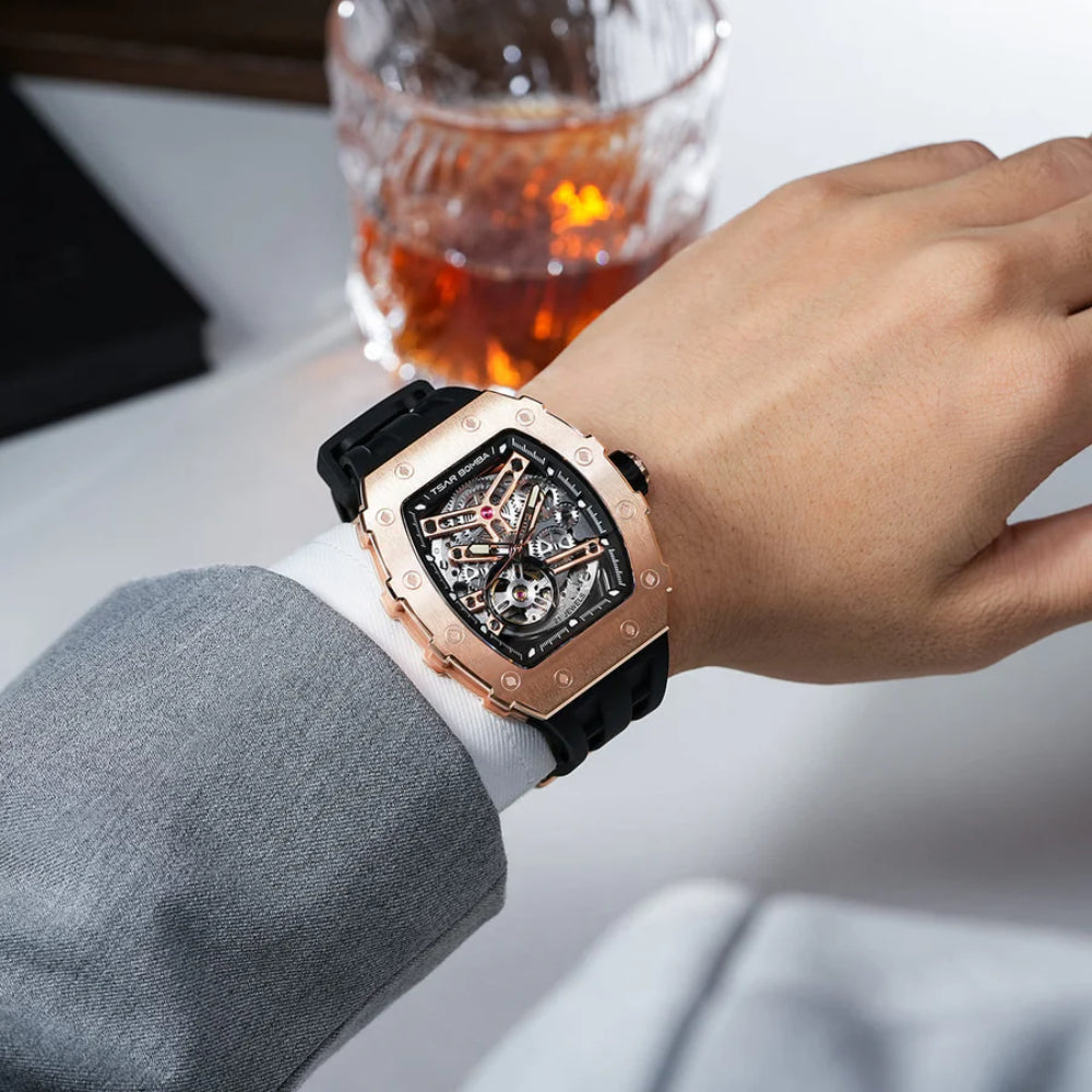 Luxury watch on a wrist with a glass of whiskey in the background