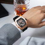 Luxury watch on a wrist with a glass of whiskey in the background