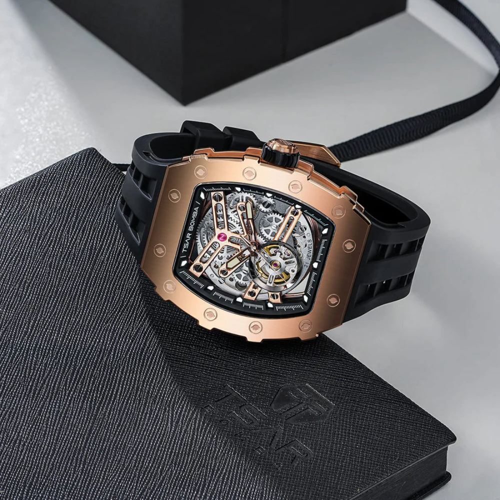 Luxury watch with rose gold case and black strap on a textured surface