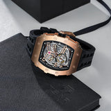 Luxury watch with rose gold case and black strap on a textured surface